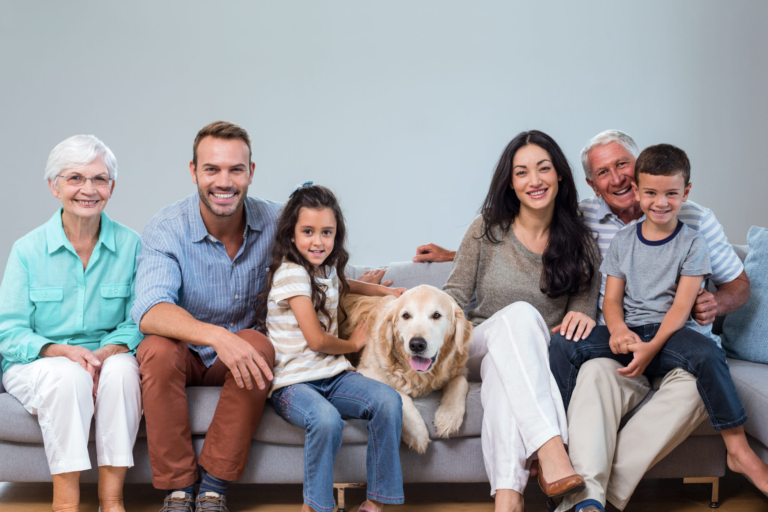 Family sitting on sofa with dog in living room