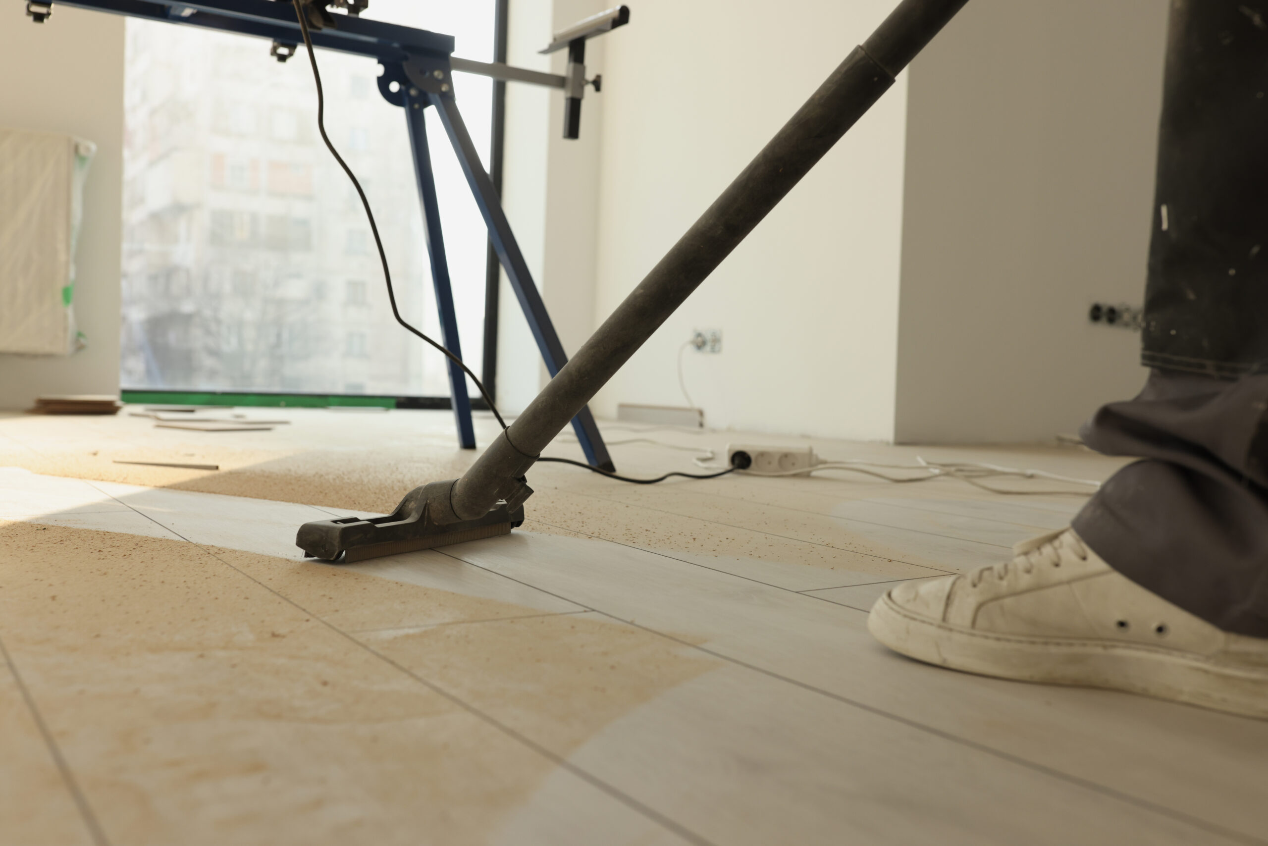 Man does industrial cleaning in room using vacuum cleaner